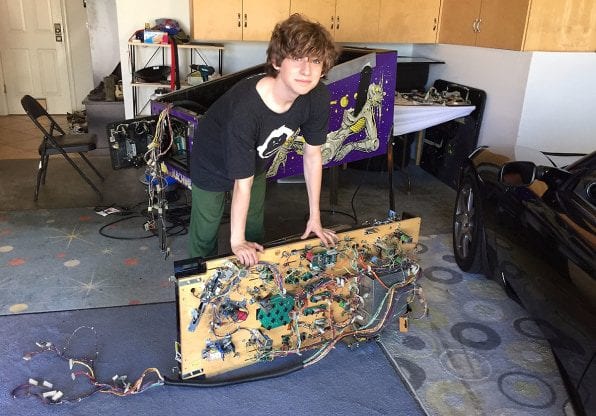 Ben Adelson with the guts of a pinball machine